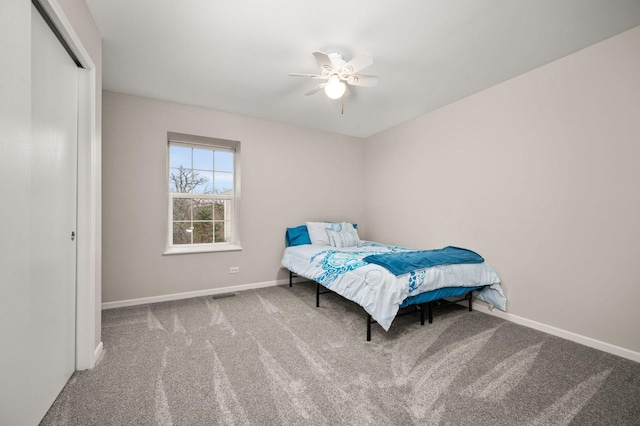 carpeted bedroom with ceiling fan and a closet