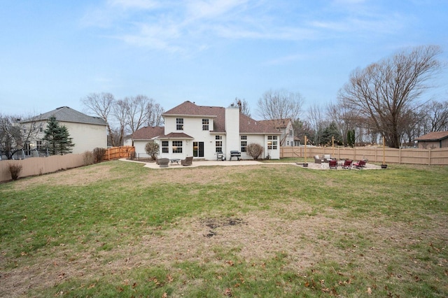 back of property featuring a yard, a patio, and an outdoor fire pit