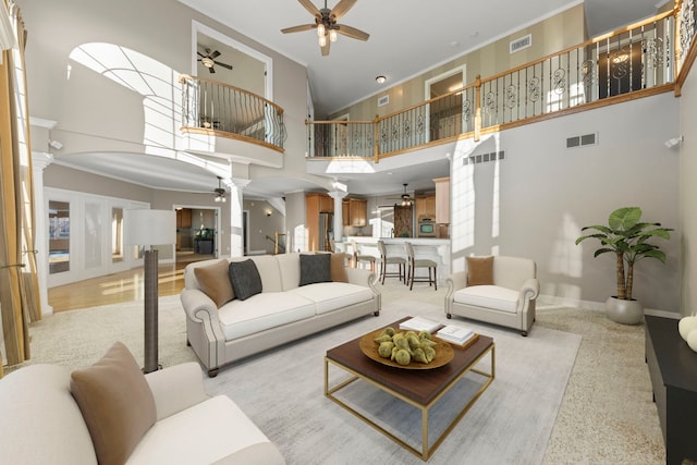 living room with ceiling fan, ornamental molding, a high ceiling, and decorative columns