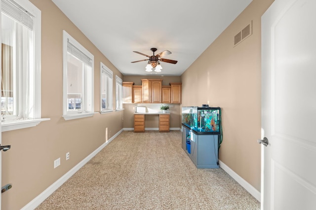 kitchen featuring ceiling fan and built in desk