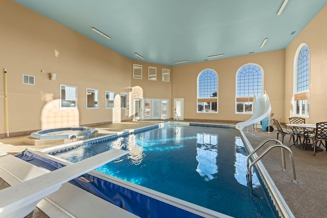 view of pool with a diving board and a water slide