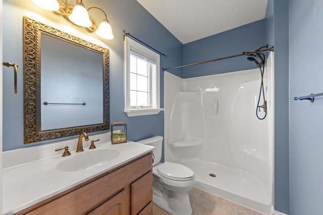 bathroom featuring toilet, tile patterned floors, walk in shower, and vanity