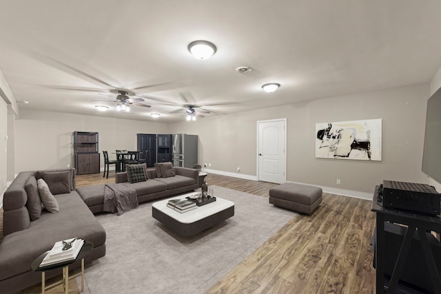 living room featuring ceiling fan and wood-type flooring