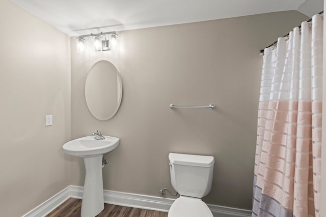 bathroom with toilet, wood-type flooring, and sink