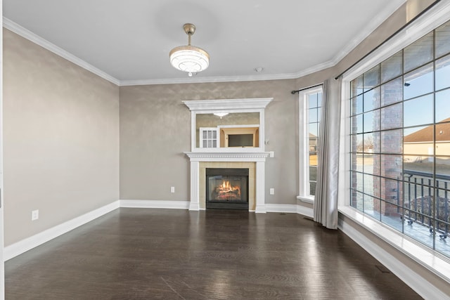 unfurnished living room featuring dark wood-type flooring, ornamental molding, and plenty of natural light