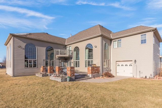 back of house with a balcony, a yard, and a garage