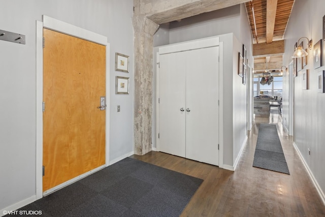 hall with dark hardwood / wood-style floors, wooden ceiling, and beamed ceiling