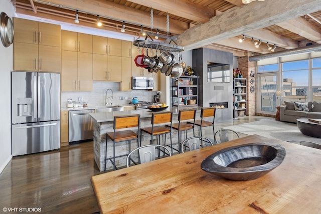 kitchen with sink, appliances with stainless steel finishes, wood ceiling, and beam ceiling