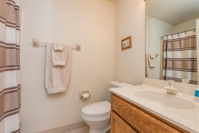 bathroom with toilet, vanity, and tile patterned flooring