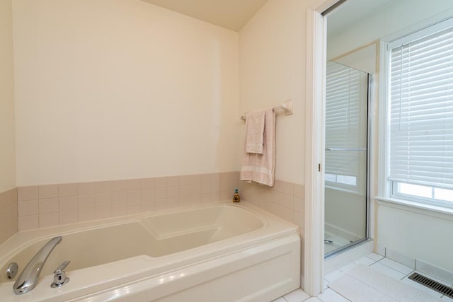 bathroom with an enclosed shower and tile patterned flooring