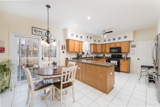 kitchen with kitchen peninsula, hanging light fixtures, sink, a wealth of natural light, and black appliances