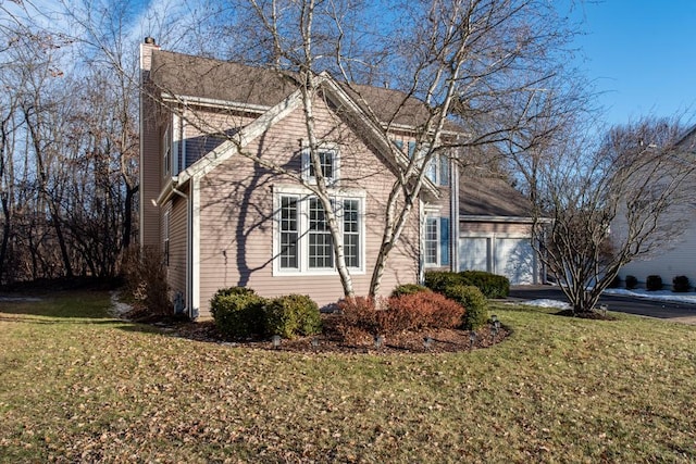 view of home's exterior with a garage and a yard