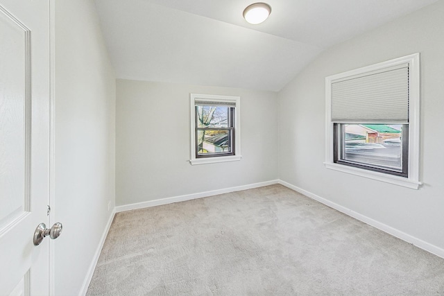 additional living space featuring light carpet and vaulted ceiling