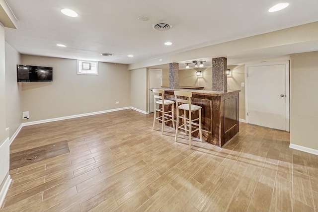 bar with light hardwood / wood-style flooring