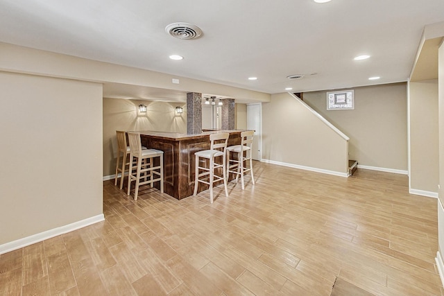 interior space featuring light wood-type flooring and bar area