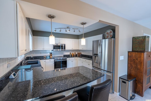 kitchen featuring sink, decorative light fixtures, kitchen peninsula, stainless steel appliances, and white cabinets