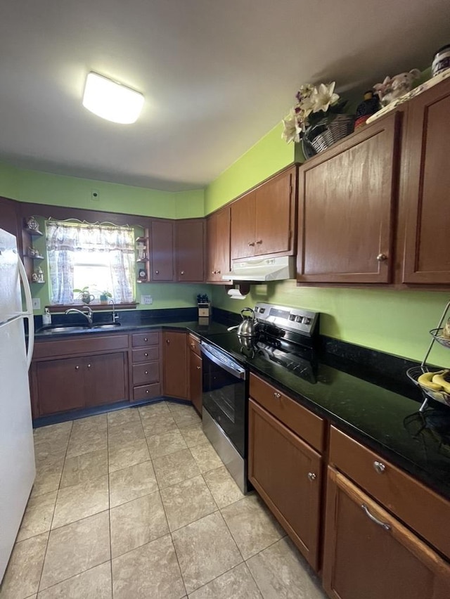 kitchen featuring white refrigerator, sink, light tile patterned floors, and stainless steel range with electric cooktop