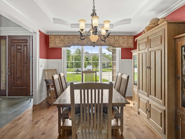 dining room featuring hardwood / wood-style flooring, crown molding, a tray ceiling, and a notable chandelier