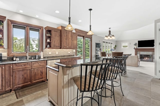 kitchen with a chandelier, a kitchen island, hanging light fixtures, and a breakfast bar area