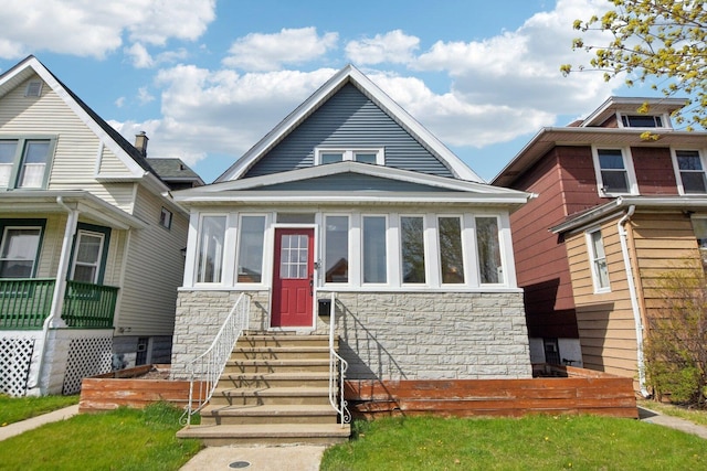 bungalow-style home with stone siding and entry steps