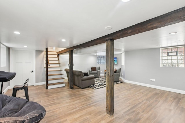 basement with light wood-style flooring, baseboards, recessed lighting, and stairs