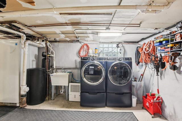 washroom with a sink, independent washer and dryer, and laundry area