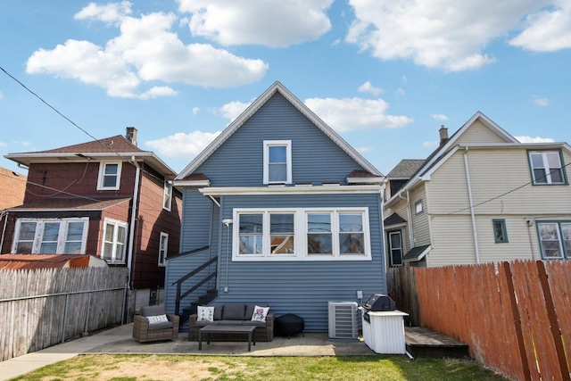rear view of house featuring cooling unit, outdoor lounge area, a patio area, and a fenced backyard