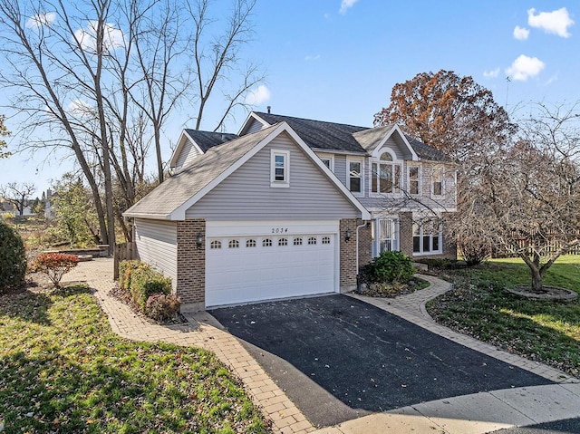 view of property featuring a garage and a front lawn