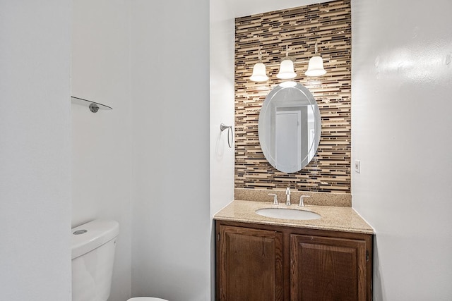 bathroom with tasteful backsplash, vanity, and toilet