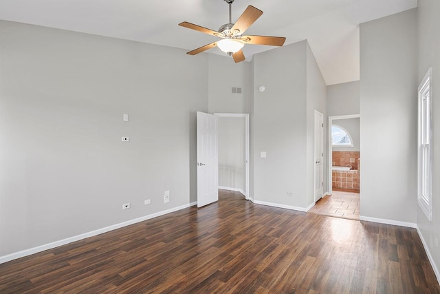 empty room with dark wood-type flooring, high vaulted ceiling, and ceiling fan