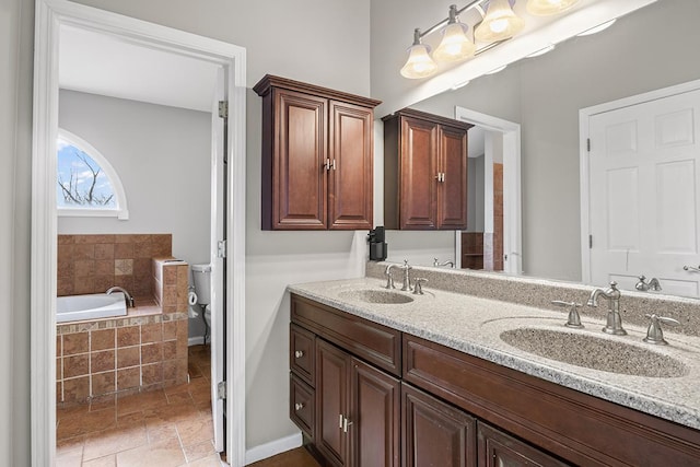 bathroom with vanity and tiled bath