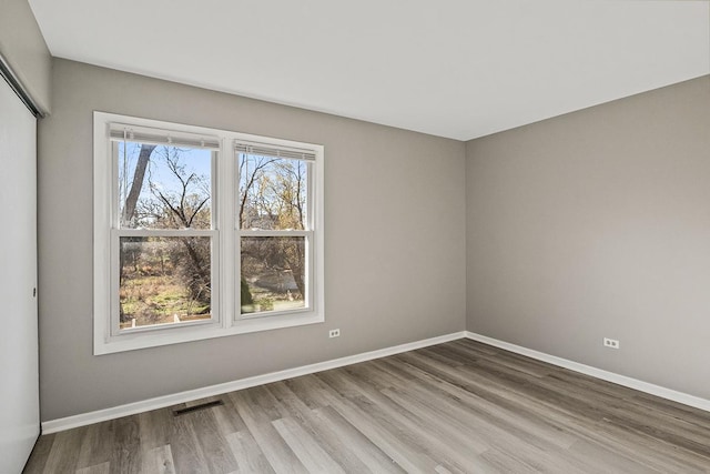 unfurnished room with hardwood / wood-style flooring