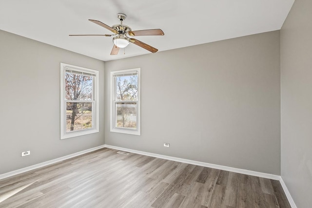 spare room with ceiling fan and light wood-type flooring