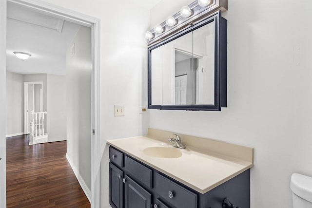 bathroom with vanity, wood-type flooring, and toilet