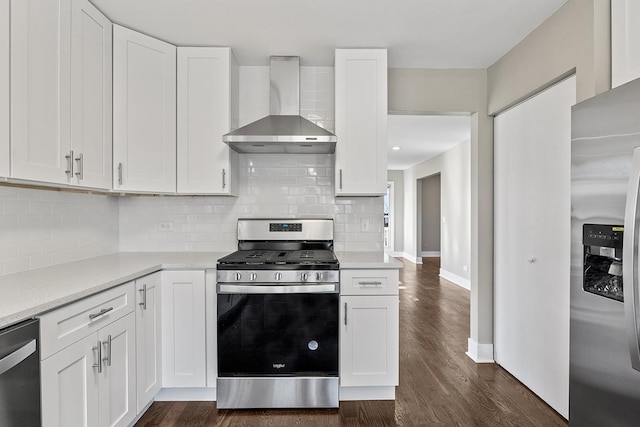 kitchen with stainless steel appliances, white cabinets, and wall chimney exhaust hood