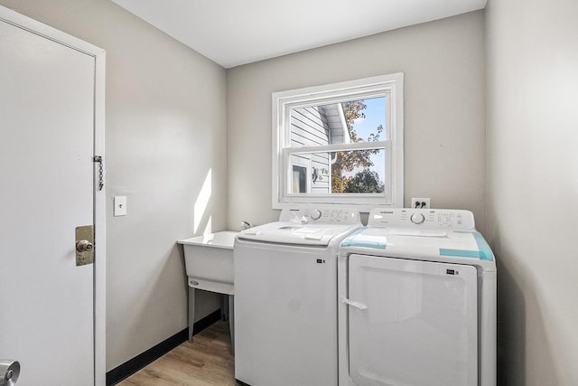 washroom with washer and clothes dryer and light hardwood / wood-style floors