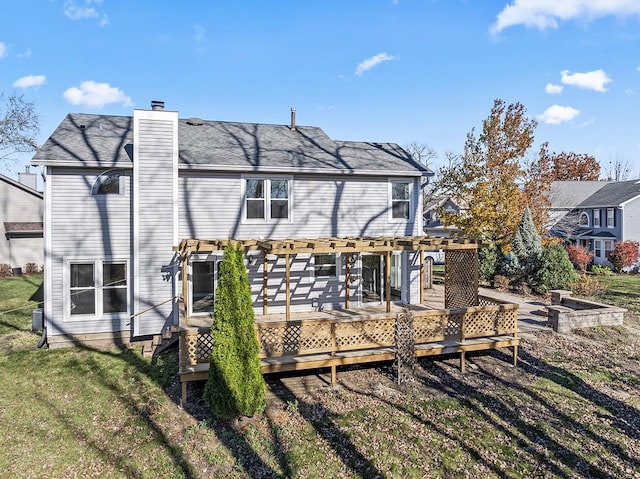 rear view of property featuring a yard, a pergola, and a deck