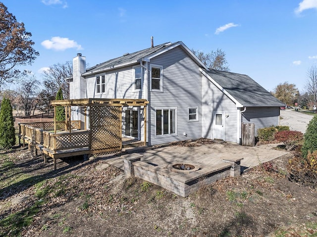 rear view of house featuring a patio, a deck, and a fire pit