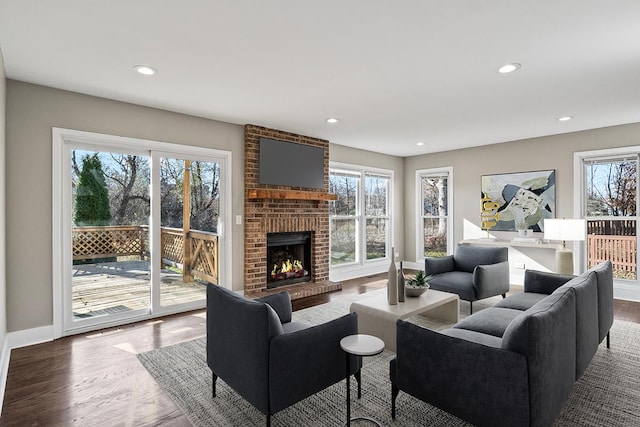 living room with hardwood / wood-style floors and a brick fireplace