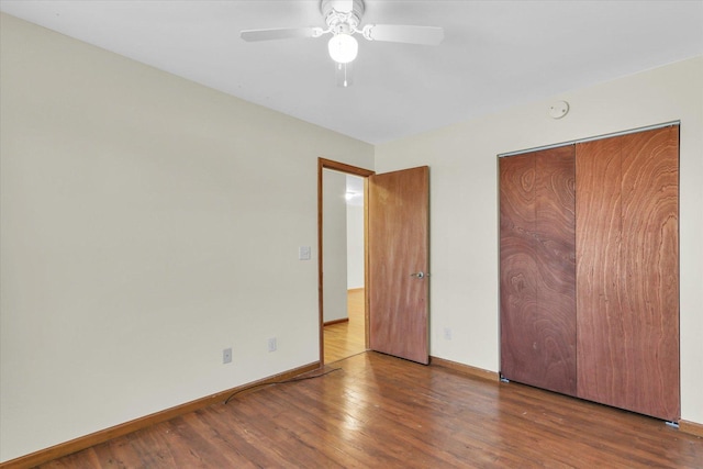 unfurnished bedroom featuring hardwood / wood-style flooring, ceiling fan, and a closet