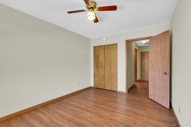 unfurnished bedroom featuring ceiling fan, a closet, and hardwood / wood-style floors