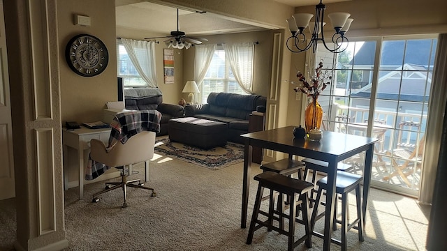 carpeted dining space with ceiling fan with notable chandelier