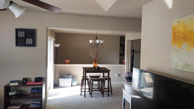 dining space with carpet floors, a textured ceiling, and an inviting chandelier