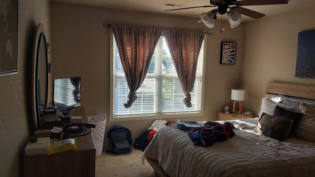 carpeted bedroom with stainless steel fridge, multiple windows, and ceiling fan