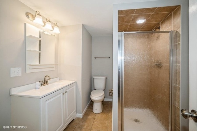 bathroom with tile patterned flooring, vanity, toilet, and walk in shower