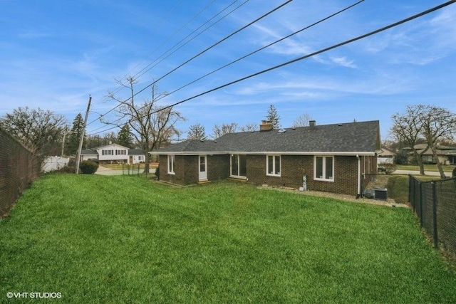 back of house with a lawn and central AC