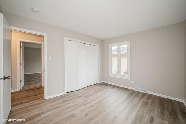 unfurnished bedroom with a closet and light wood-type flooring