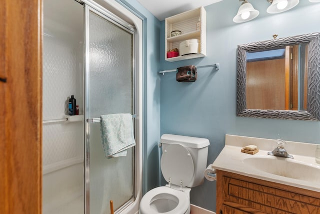 bathroom with vanity, toilet, and a shower with shower door