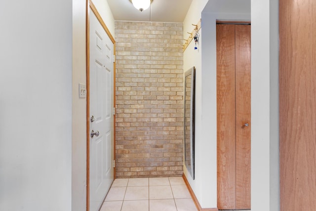 bathroom featuring brick wall and tile patterned floors