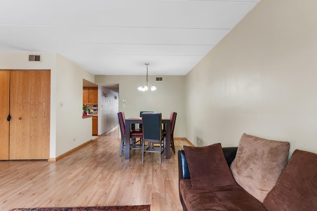 dining area featuring an inviting chandelier and light hardwood / wood-style flooring